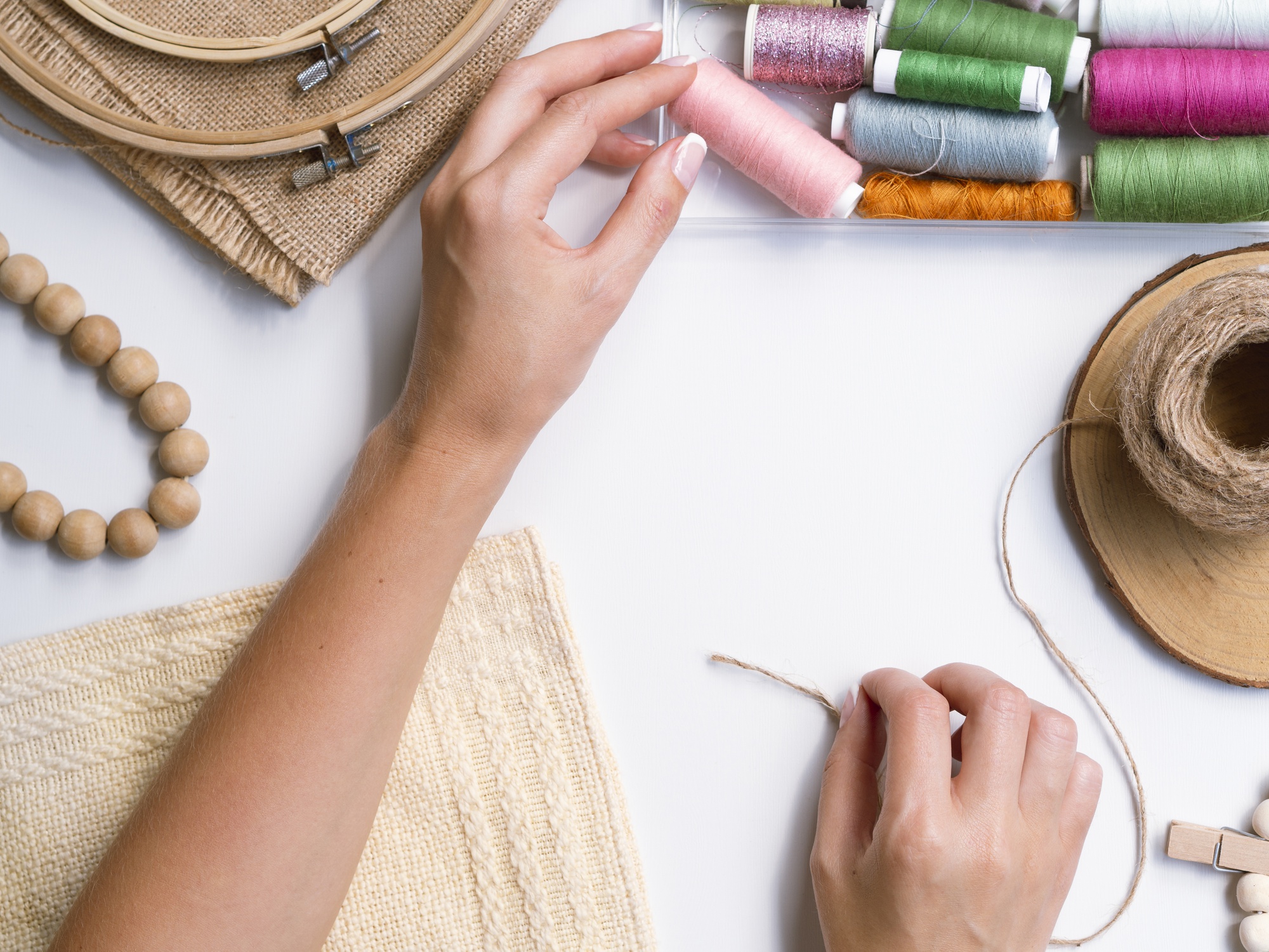 artisan hands embroidering silk thread on linen